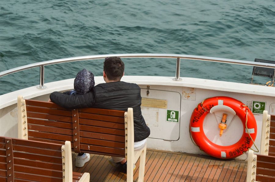 Couple on the bow of a ship looking out to sea