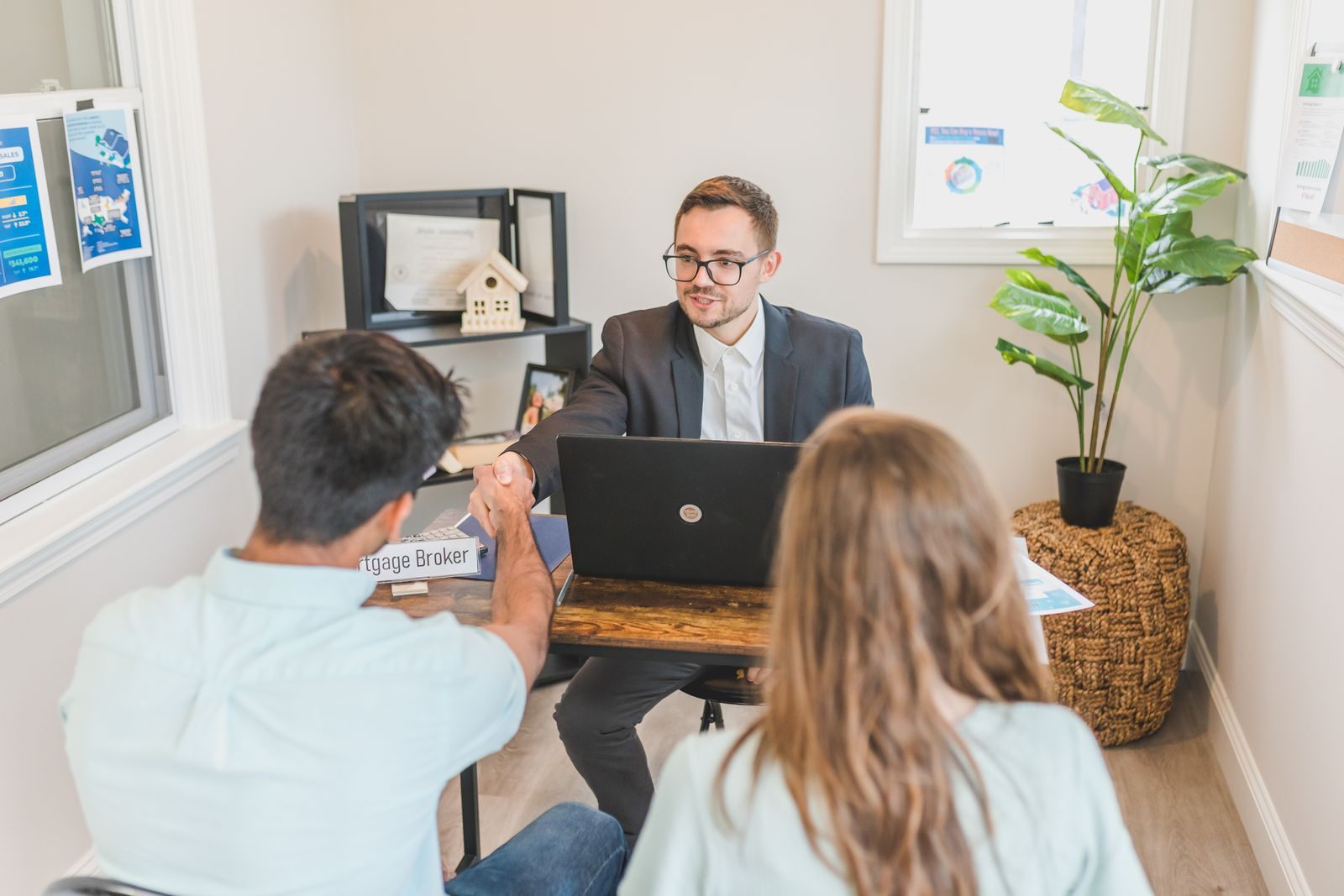 Advisor with a laptop walking a couple through how to sell cruises step by step in a small office